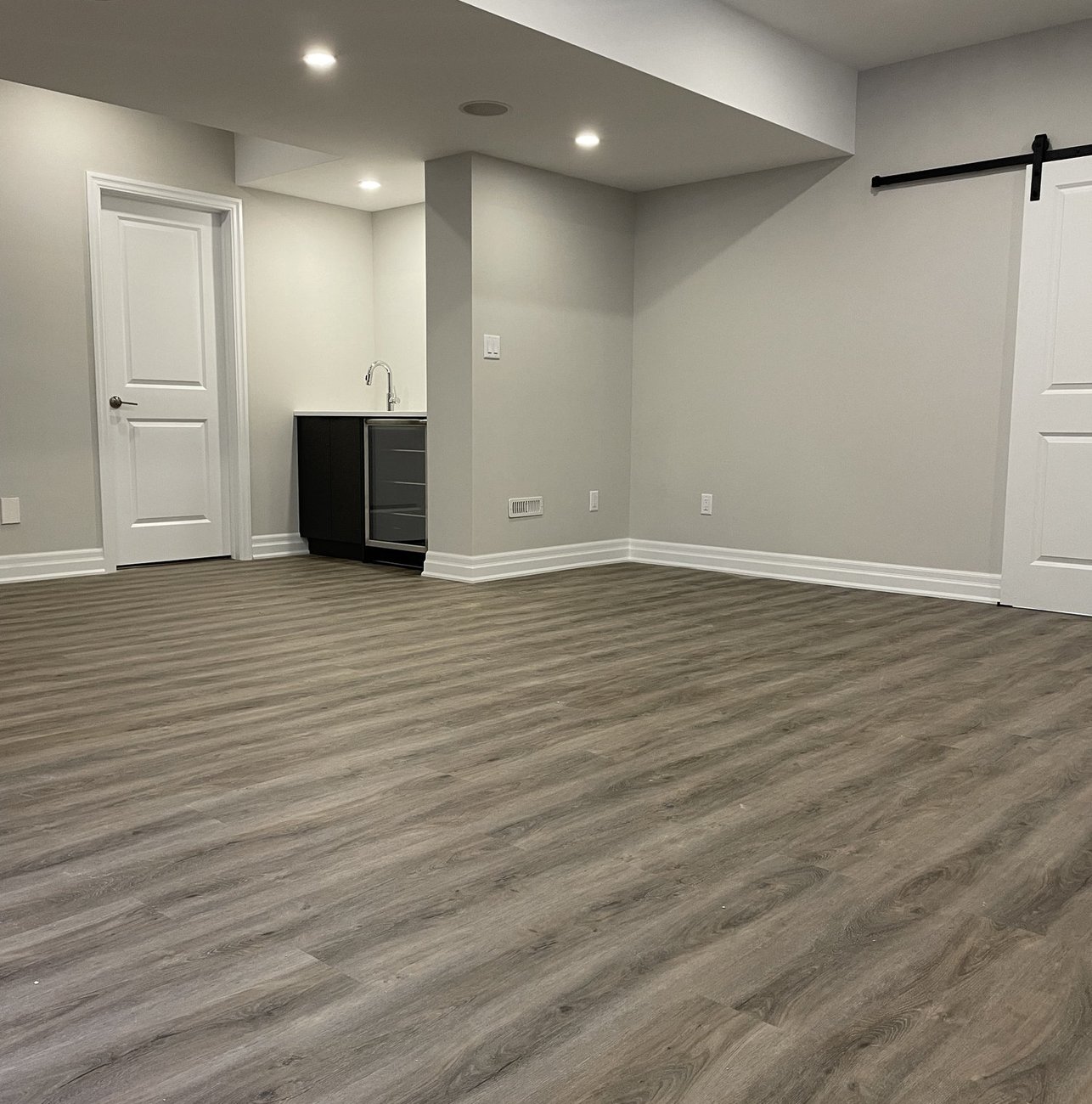 finished basement with wet bar and barn door built by Baird Construction in Woodstock ON